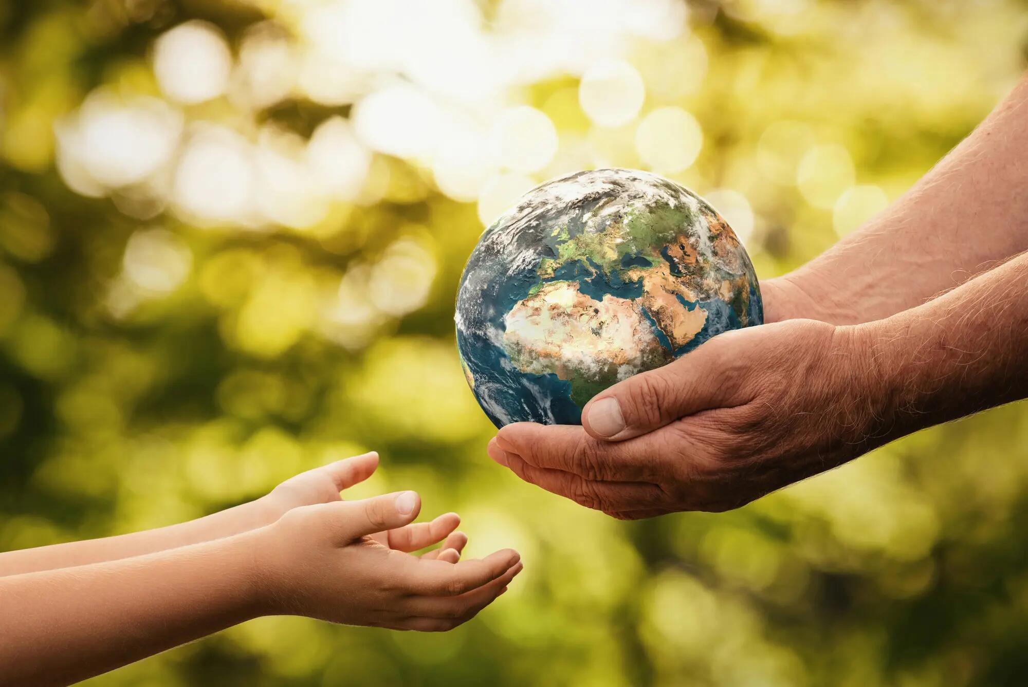 Senior hands giving earth to a child